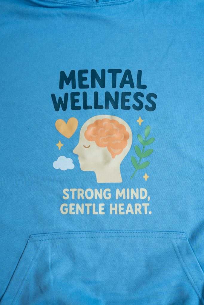 Drawing of head with brain visible, stars, heart, cloud and leaves around it. It says "Mental Wellness. Strong Mind, Gentle Heart."